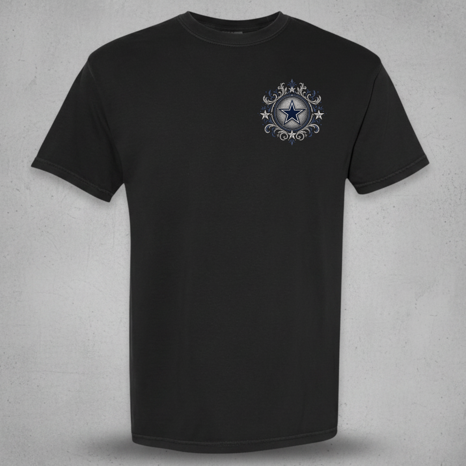A black short-sleeve crewneck t-shirt with a small circular graphic on the left chest featuring a blue star and silver decorative elements, displayed against a textured gray background.